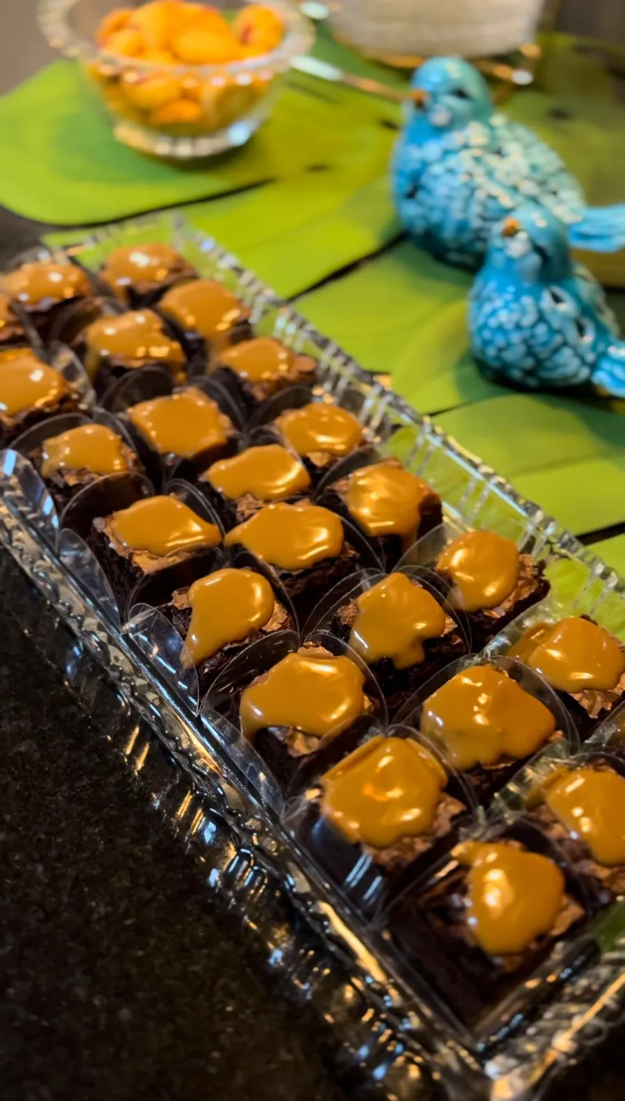 Bandeja de brownies com doce de leite em uma mesa de festa